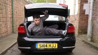 Bobby climbing out of the boot of a car.