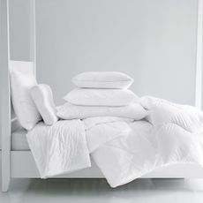 White double bed with white bedding and pillows