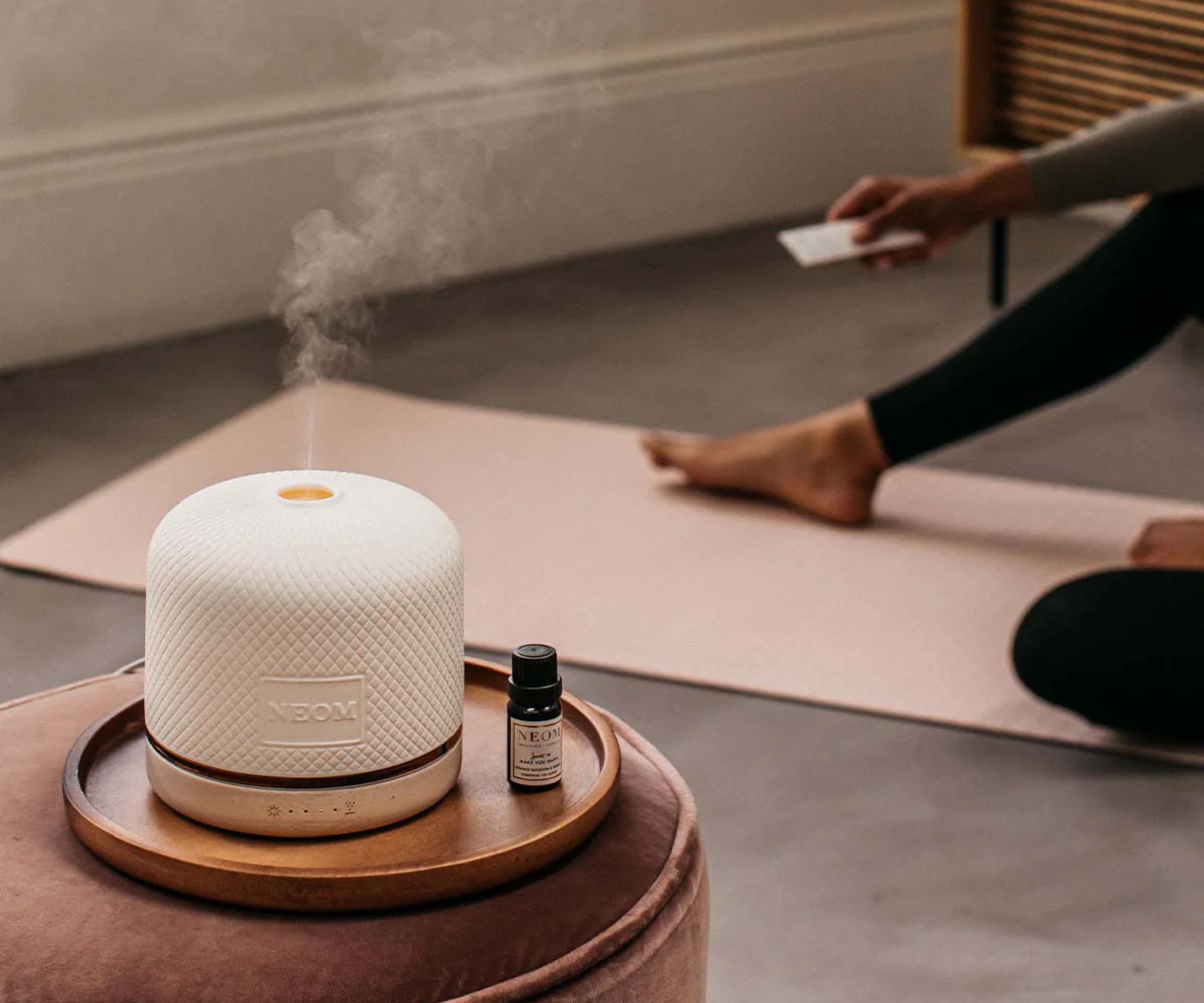NEOM Wellbeing Pod Luxe on a table against a gray background.