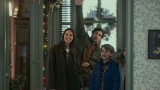 Jason Schwartzman and Felicity Jones stand in doorway with kids waving in movie Oh.What.Fun