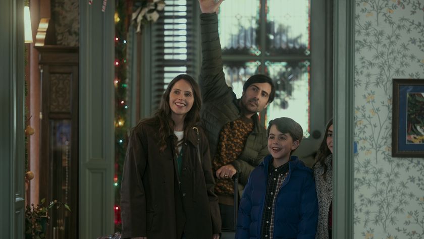 Jason Schwartzman and Felicity Jones stand in doorway with kids waving in movie Oh.What.Fun