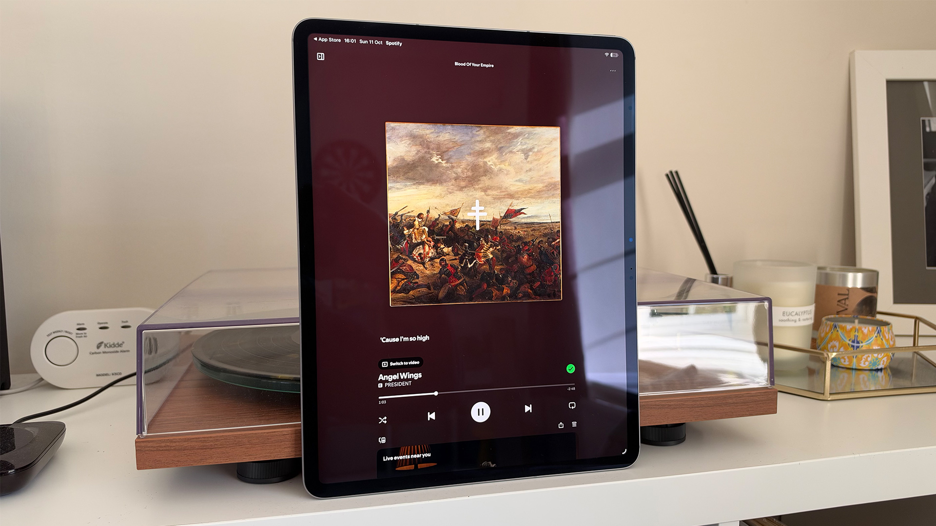 Apple iPad Air 13-inch (M4) tablet leaning upright against turntable, on screen is President album playing on music player