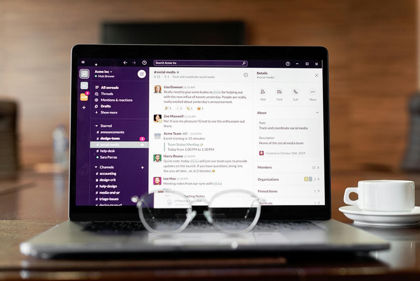 Laptop screen showing business app messaging interface with team channels and conversations.