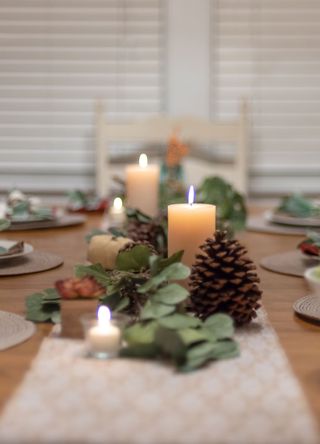 picture of table with centre piece of candles and Christmas decor