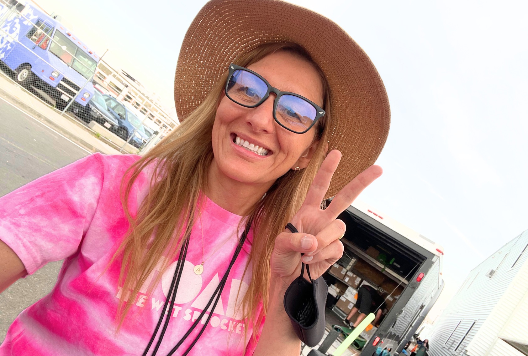 A woman with a floppy hat wearing a pink t-shirt