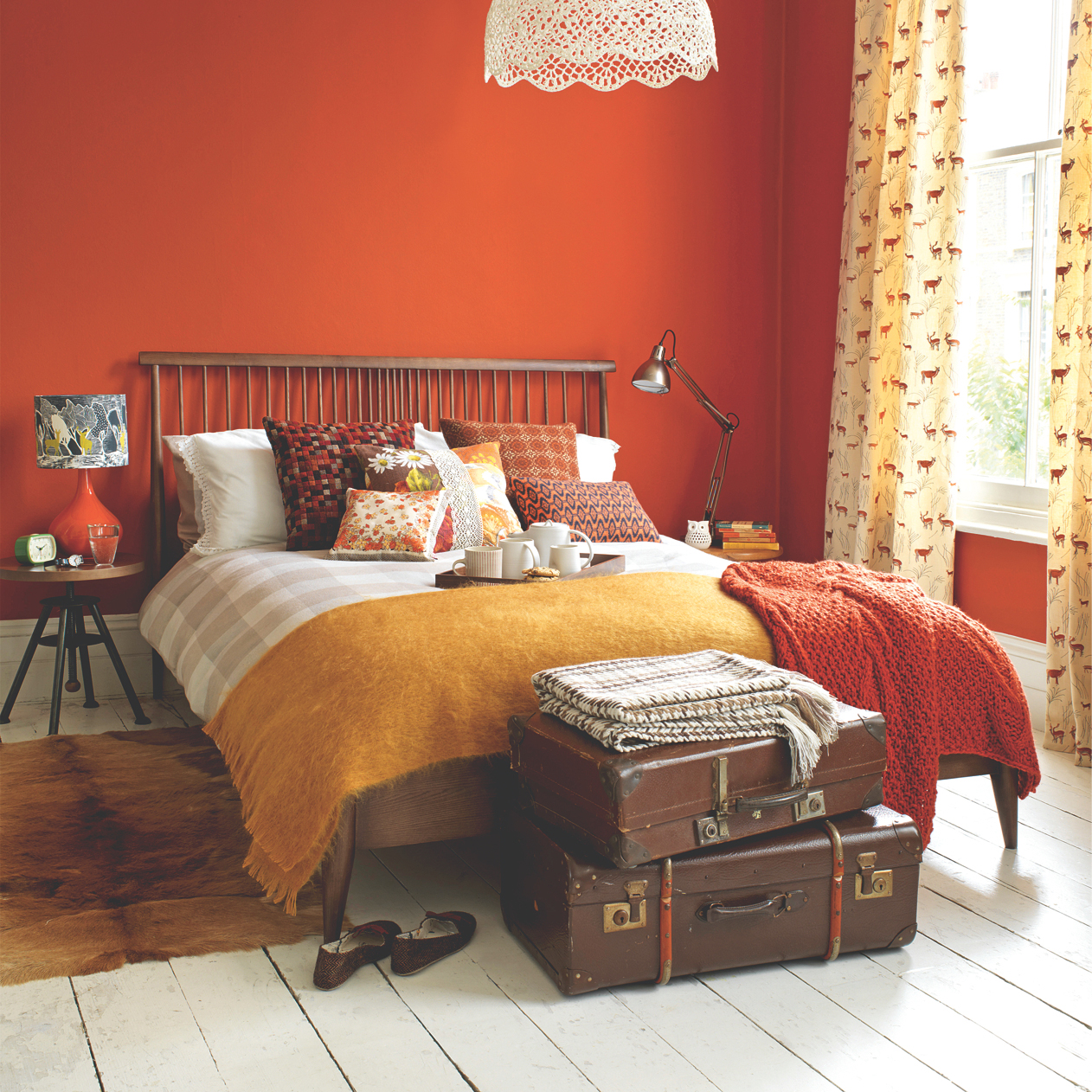 bedroom with orange wall and bed with bedside lamp