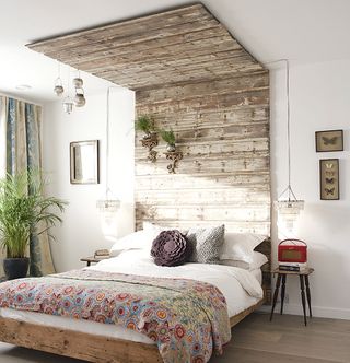 bedroom with wooden plank headboard and ceiling