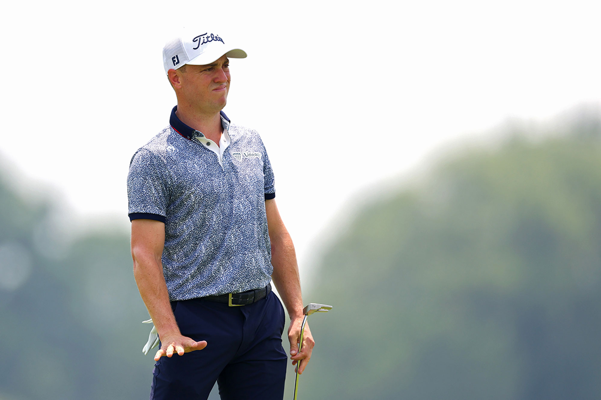 Justin Thomas indicating with his hand for the golf ball to slow down on the fast putting surfaces at Oakmont Country Club for the US Open