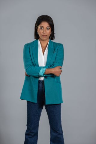 A posed shot of Priyanga Burford as Nicky in Before We Die, wearing jeans, a white blouse and an aqua-coloured blazer