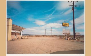 Yellow Market Sign and Parking Lot