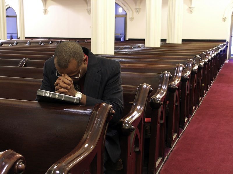 A man prays alone in church.