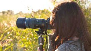 author using the OM-1 Mark II on a tripod in a nature reserve