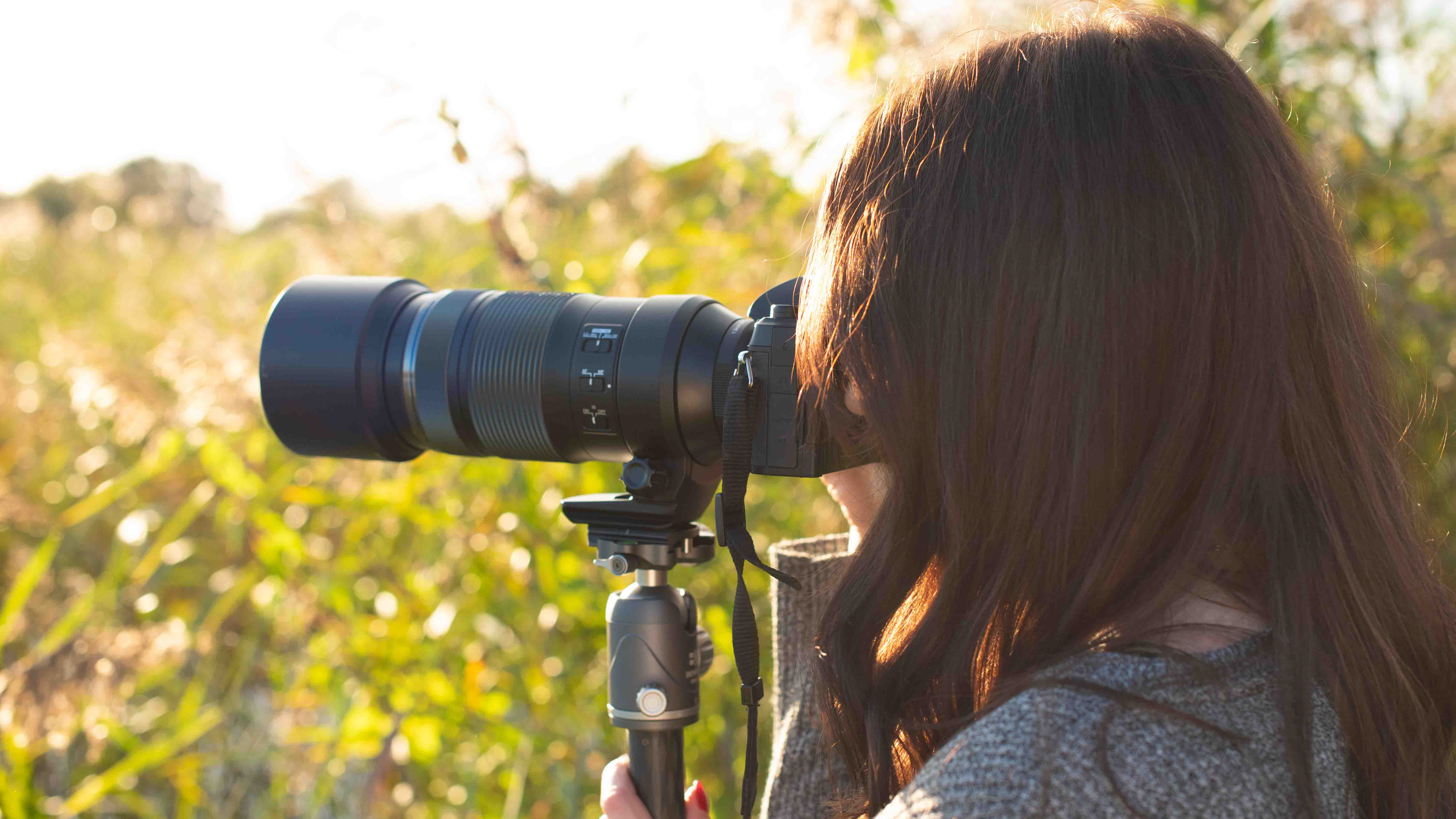 author using the OM-1 Mark II on a tripod in a nature reserve