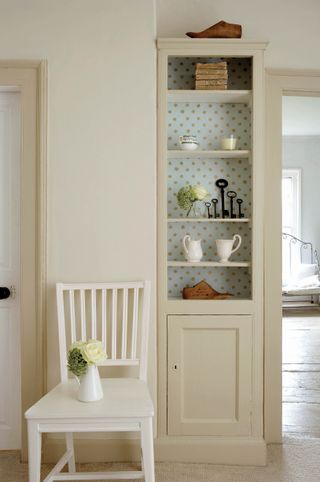 Clay Mid and Clay Pale paint from Little Greene in a light and bright hallway with a chair and in built shelving and storage