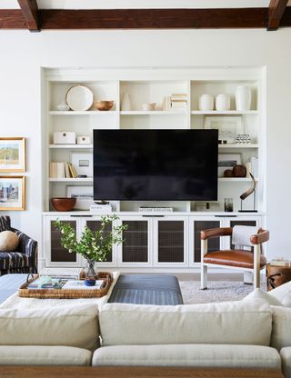 Small living room with white walls, bespoke storage and TV