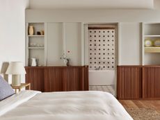 A bedroom with white walls, and wooden console 