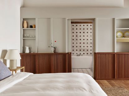 A bedroom with white walls, and wooden console 