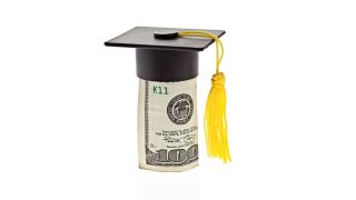 A rolled up 100 dollar bill wears a graduation cap with tassel