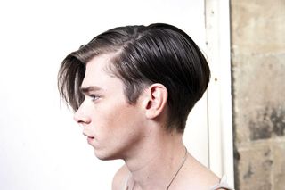 side profile of male model with dark hair and long fringe