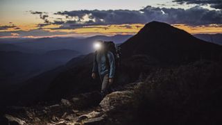 A man hiking at night with a head torch