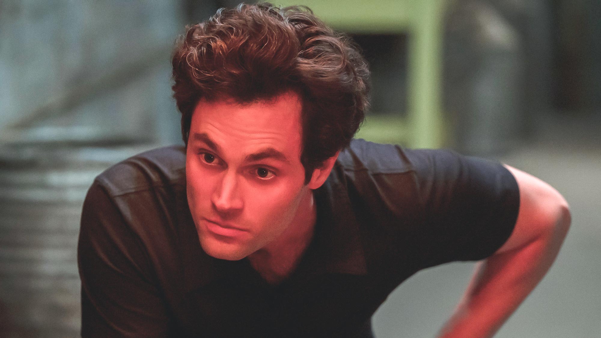 PENN BADGLEY glares menacingly under red light as JOE GOLDBERG in episode 302 of YOU