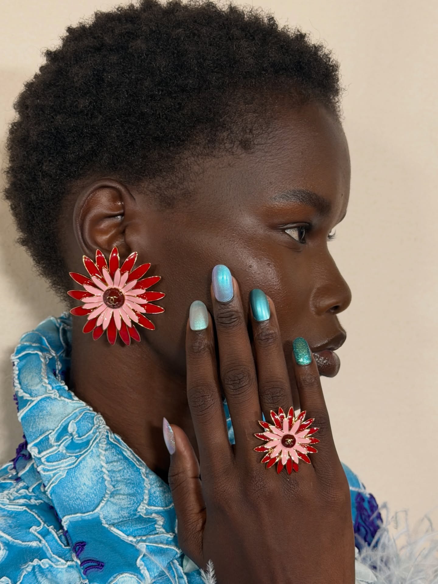 An image of a model at the Chanel Cruise 26/27 show wearing seaglass nails.