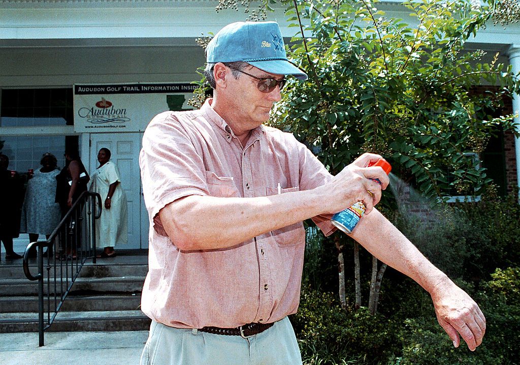 Man sprays mosquito repellant