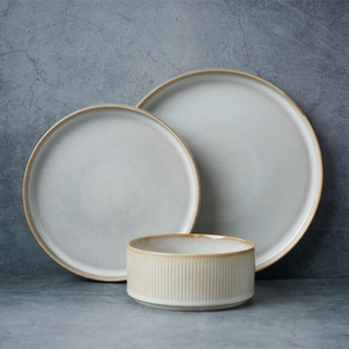 Two plates and a bowl with a rustic, off-white finish