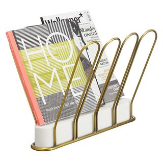 A yellow metal magazine rack holding various magazines.
