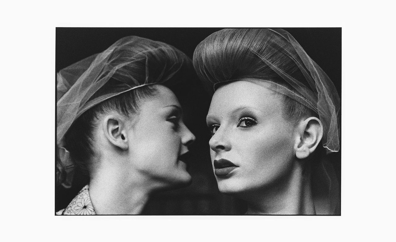 two ladies wearing hairnets that could be whispering to eachother