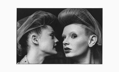 two ladies wearing hairnets that could be whispering to eachother