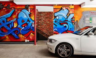 White car parked outside colourful graffiti art display