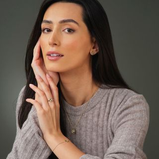 Woman looking at camera, holding her hands to her face