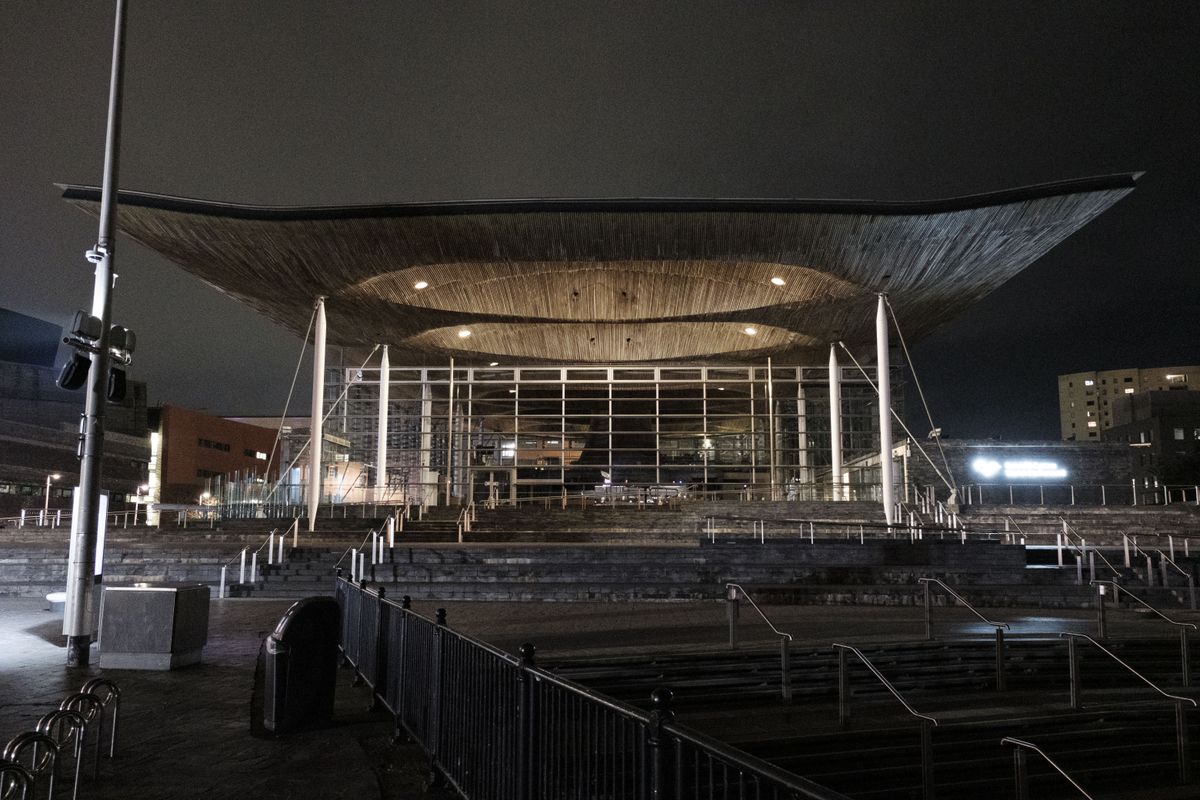 A photo of the Cardiff Senedd building, taken at night.