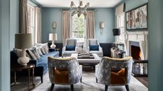 Blue living room with tall windows and a fireplace