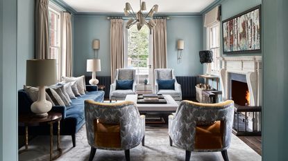 Blue living room with tall windows and a fireplace