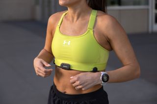 A woman wearing the Garmin HRM-Fit under her sports bra