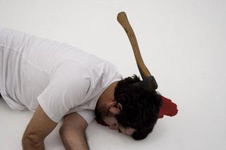 Man laying on the floor with axe in his head