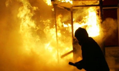 A fireman tries to extinguish a fire as protesters clash with police outside the parliament buildings in Athens. Greeks tried unsuccessfully to stop the government from approving more budget 