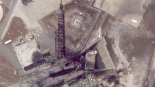 A charred black tower stands over debris after an exposion.