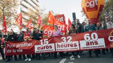 Workers protest in Paris on 27 October for higher pay and shorter working hours