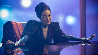 Philippa Georgiou (Michelle Yeoh) sitting behind a desk in her nightclub in the Star Trek: Section 31 movie.