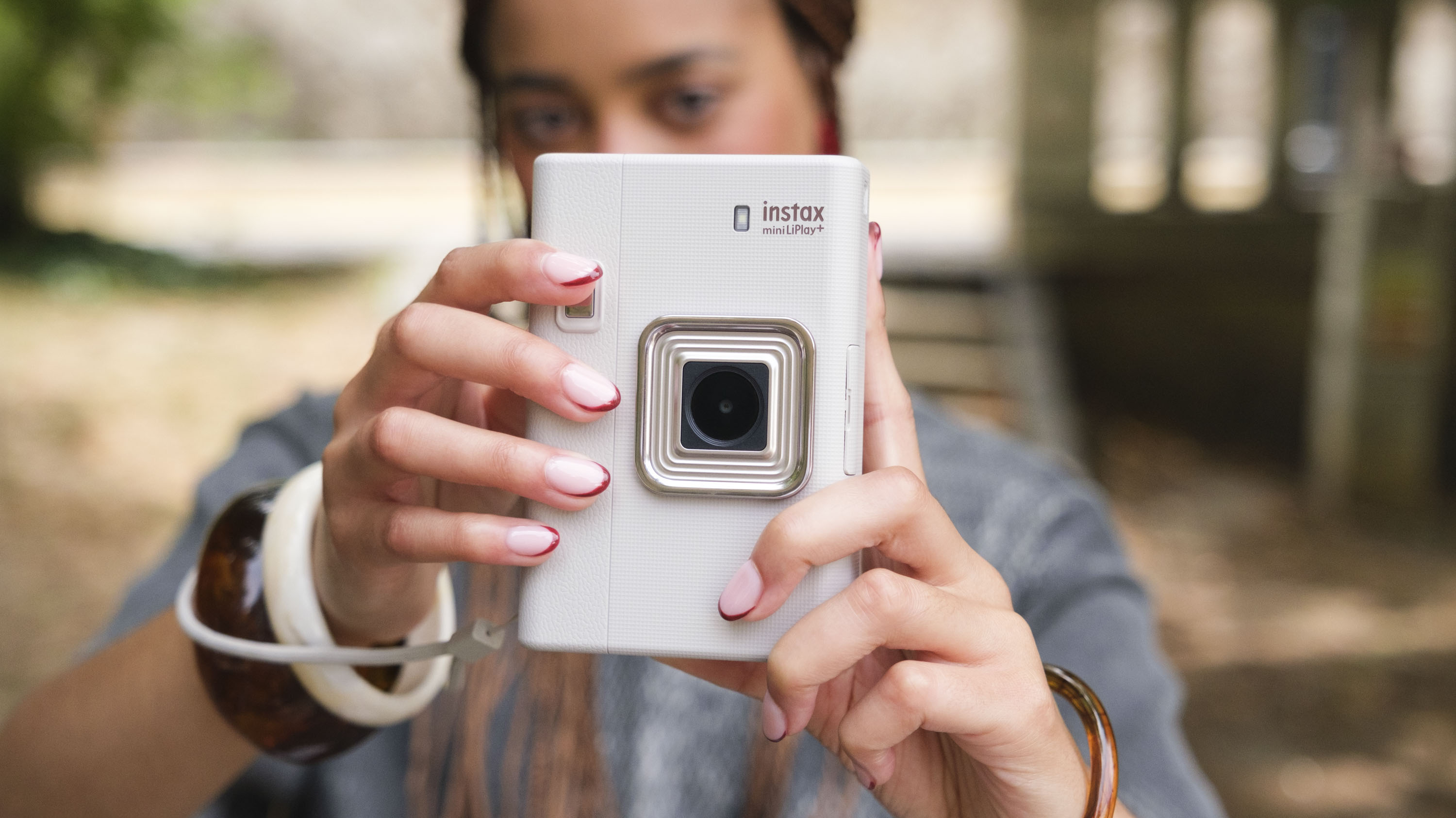 Fujifilm Instax mini LiPlay+ hybrid instant camera in woman's hands