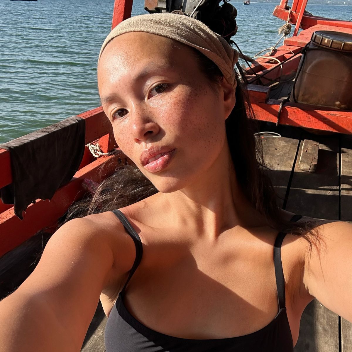 A woman with glowing skin on a boat.