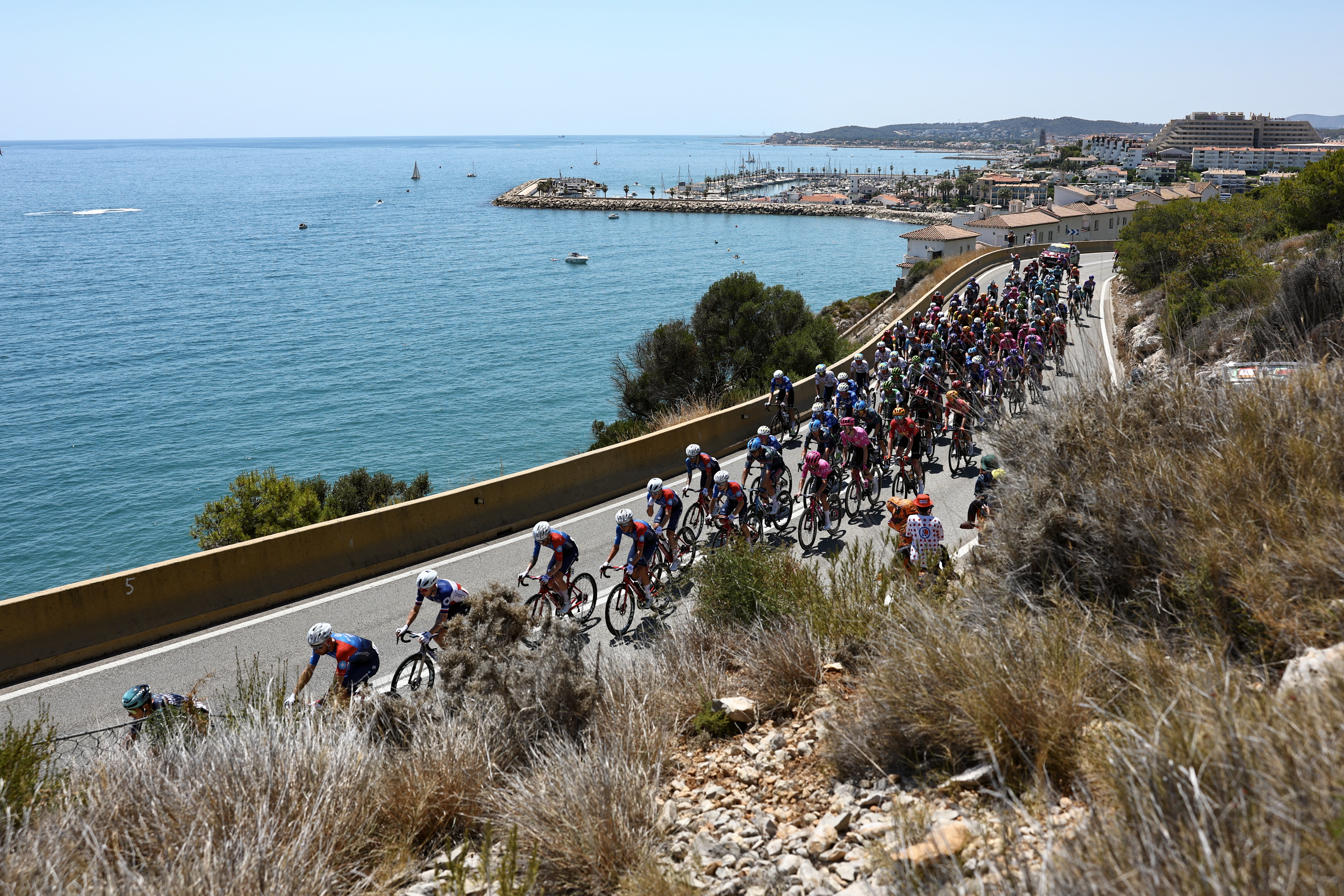 The pack of riders (peloton) cycles along the Mediterranean coastline near Sitges during the 2nd stage of the 113th edition of the Tour de France cycling race, 168,5 km between Tarragona and Barcelona in northeastern Spain, on July 5, 2026. (Photo by Anne-Christine POUJOULAT / AFP)