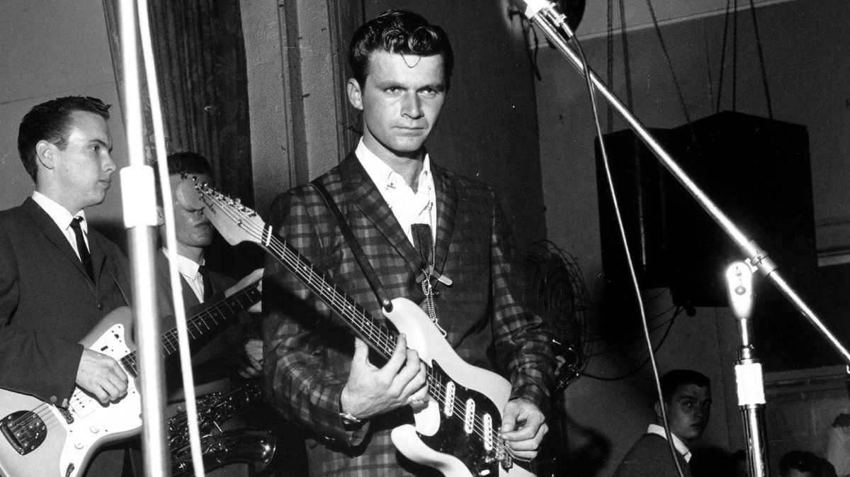 Dick Dale, wielding a Fender Stratocaster, performs onstage