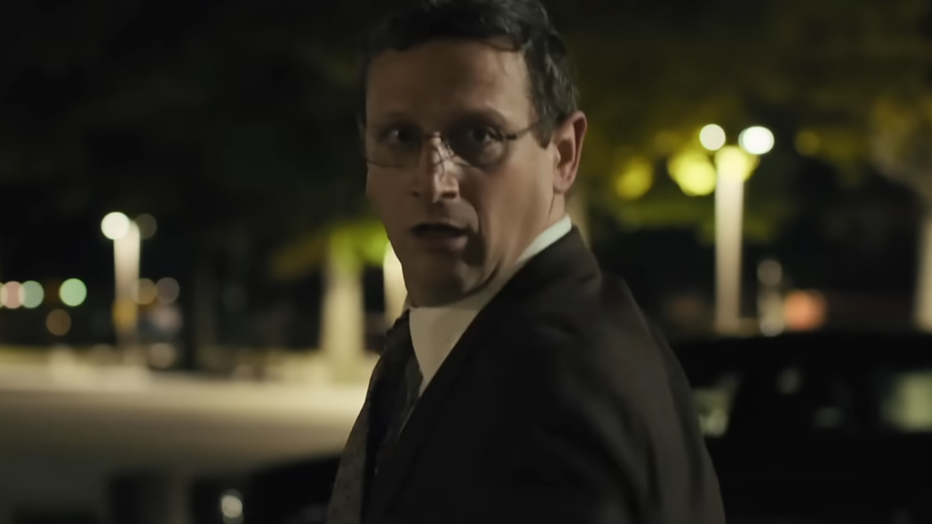 Tim Robinson as Ron Trosper, looking back over his shoulder as he runs away