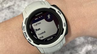 Garmin Instinct 2 with white case and band on person's wrist