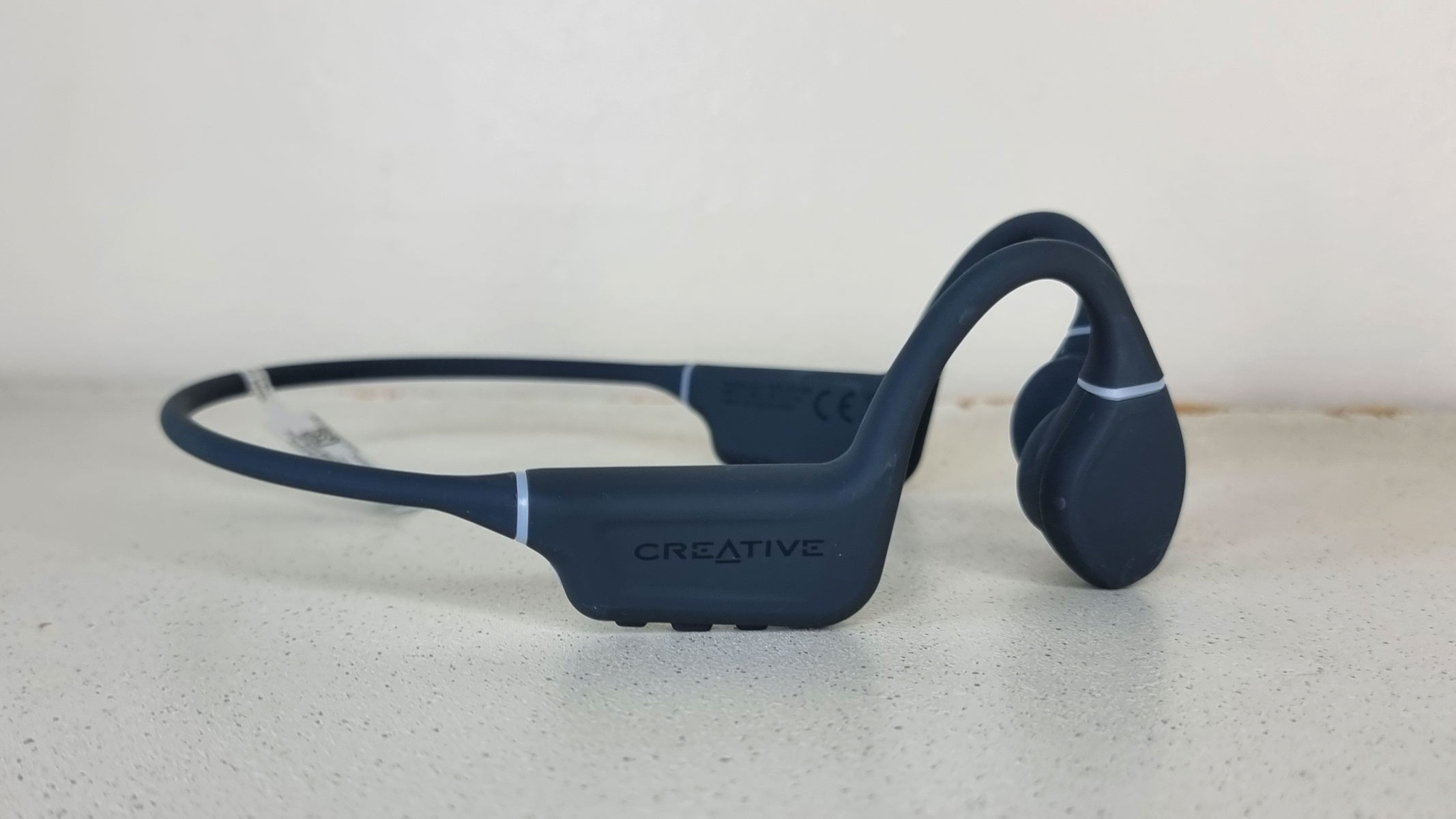 Creative Outlier Free bone conduction headphones on a white table