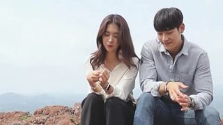 a man and a woman sit outdoors, in the korean show 'love catcher'